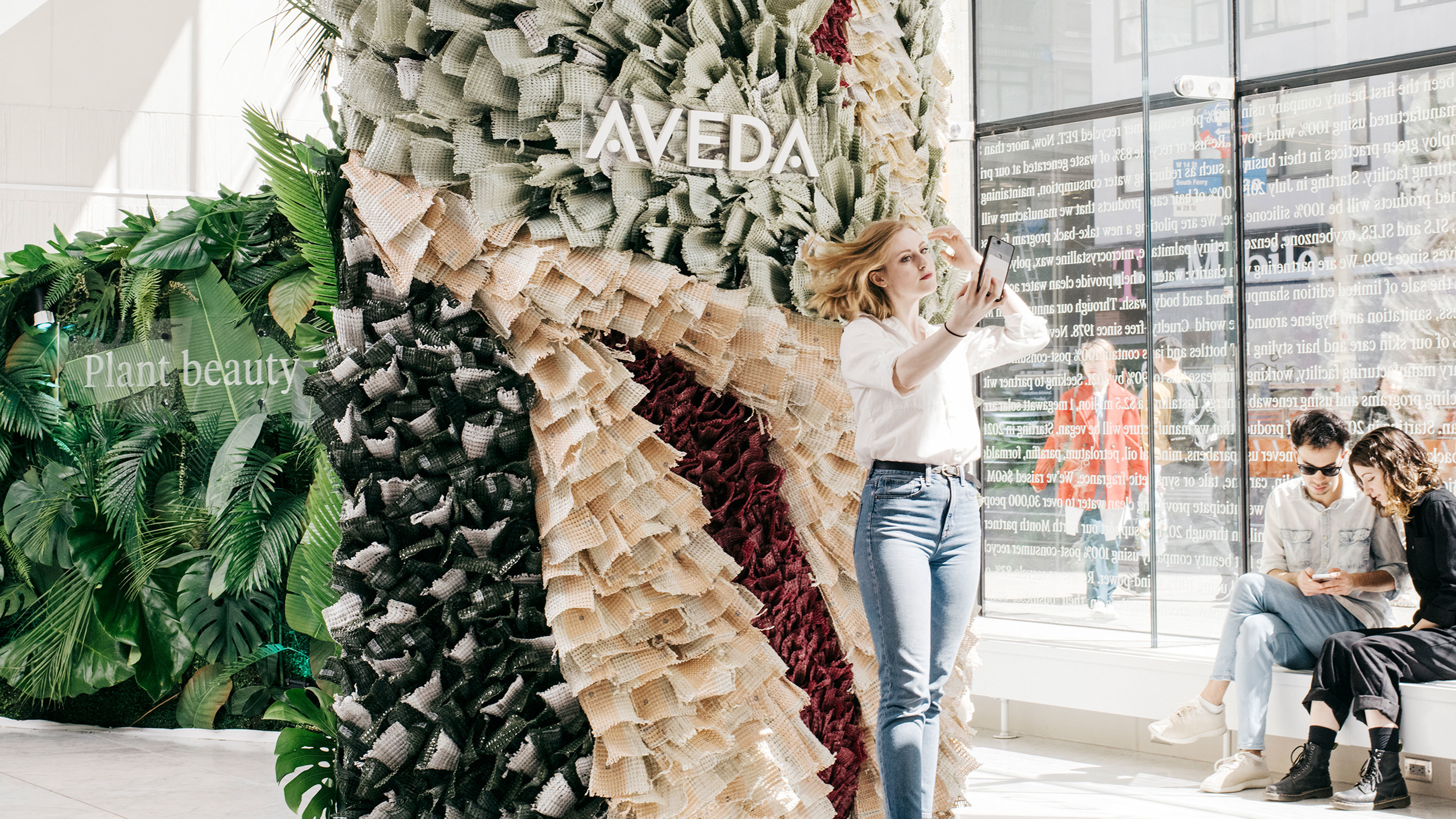 Model posing in front of the Aveda plastic bottle installation.