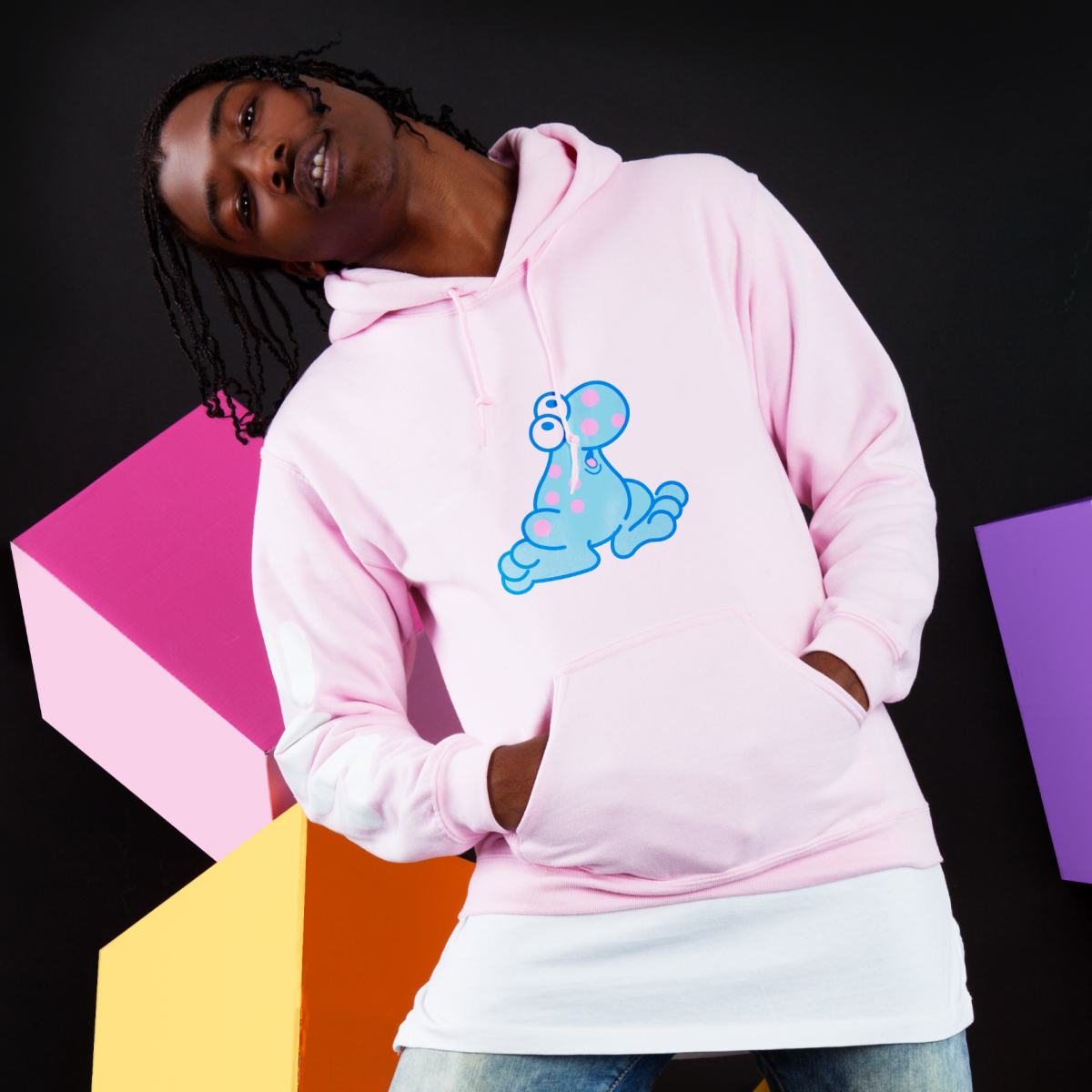 A young man wearing a Nerds-branded hoodie against a backdrop of colorful dimensional blocks.