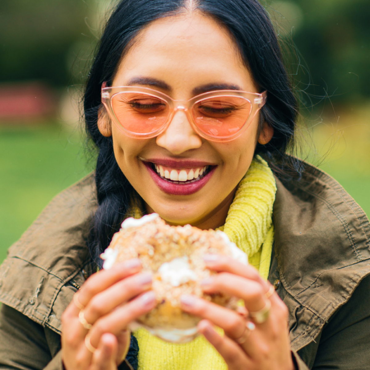 A woman holding a bagel with cream cheese