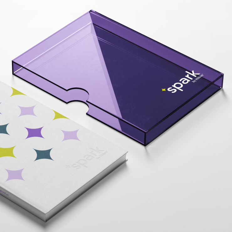 A Spark by Hilton promotional book next to a clear purple branded case