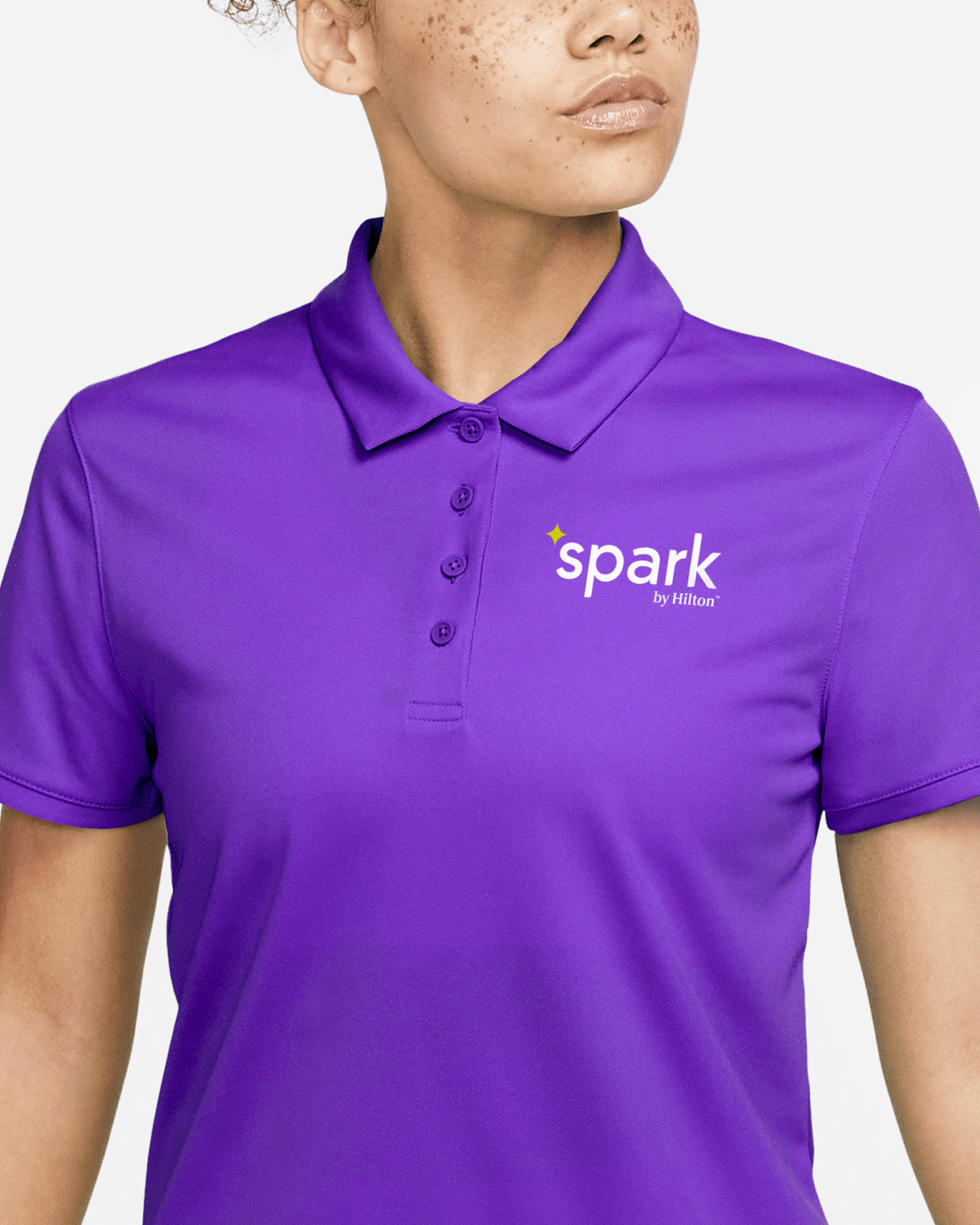 A purple Spark by Hilton employee uniform