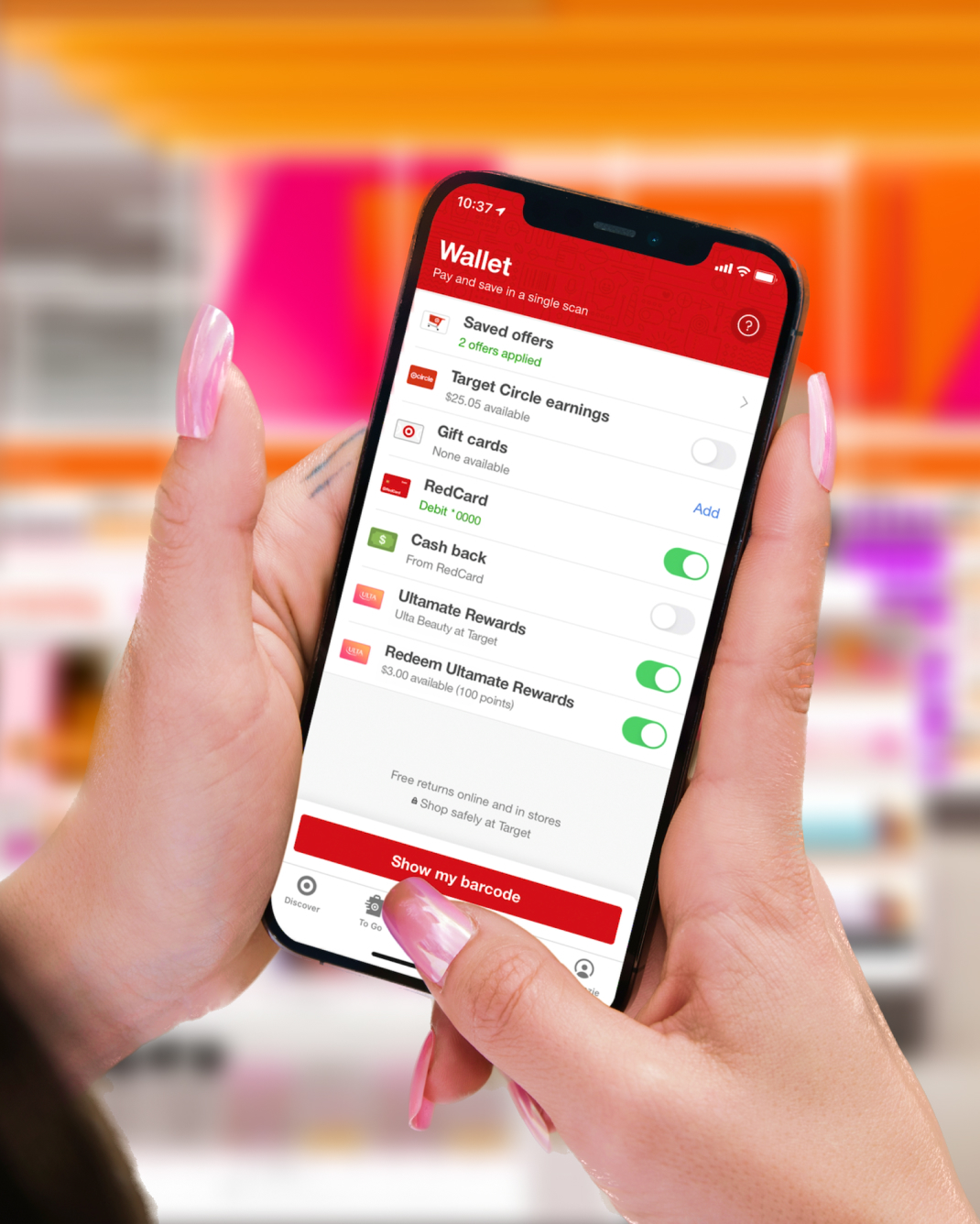 A woman holding a smartphone showing her Target app Wallet screen, including her Ultamate Rewards membership.